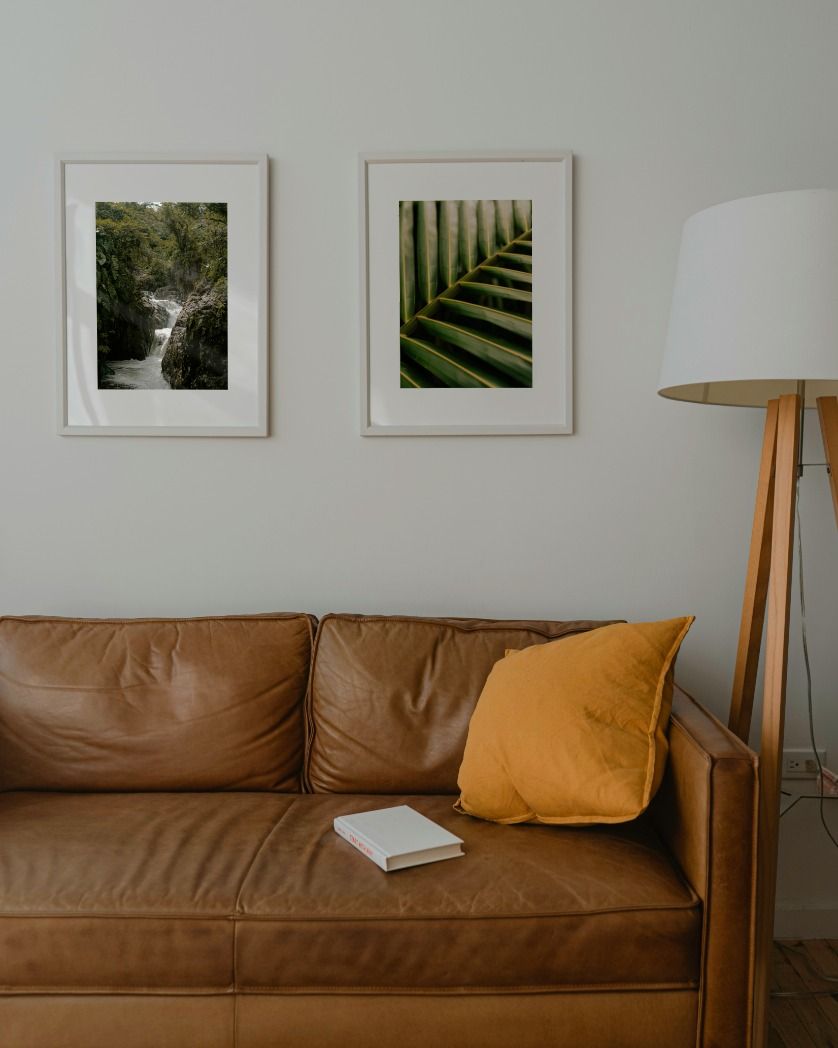 couch with a pillow next to a standing lamp